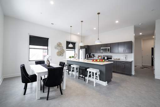 A modern kitchen with a dining table and chairs.