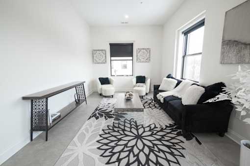 A black and white living room with a rug and a couch.