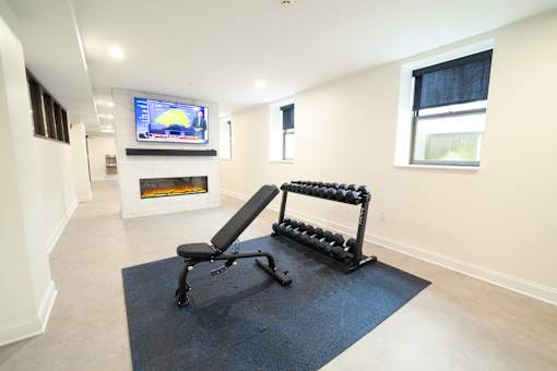 A black and white exercise machine in a room with a fireplace and a television.