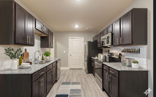 A kitchen with dark brown cabinets and a white door.