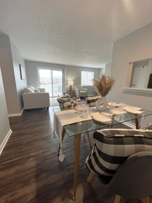 an open concept living room and dining room with hardwood flooring and a sliding glass doorat Centerpointe Apartments, Canandaigua, 14424