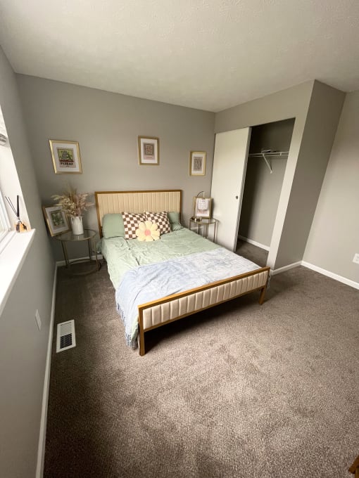 a bedroom with gray walls and a bed with a blue comforterat Centerpointe Apartments, Canandaigua, NY, 14424