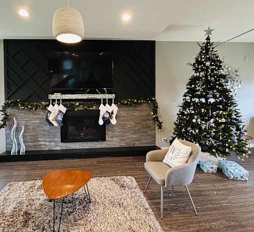 A living room with a fireplace, a chair, a table, and a Christmas tree at Woodland Ridge, Woodridge, Illinois, 60517