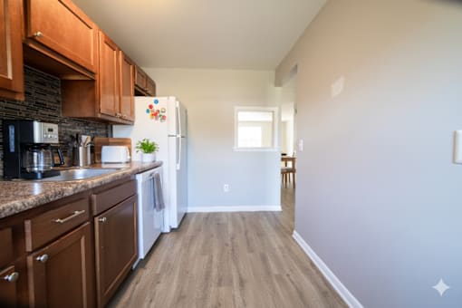 A kitchen with wooden cabinets and a white refrigerator. at Willowbrooke Apartments & Townhomes, New York