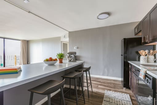 A kitchen with a white countertop and a black refrigerator. at Woodland Ridge Apartments, Woodridge, IL