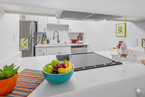 A bowl of fruit sits on a kitchen counter.