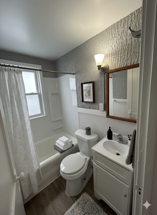 A bathroom with a toilet, sink, and bathtub.