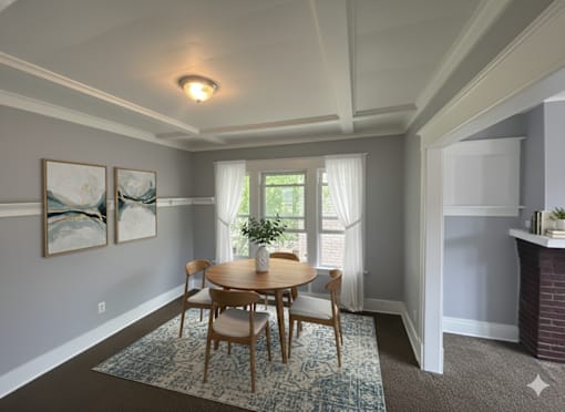 A dining room with a table and chairs.