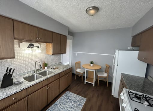 A kitchen with wooden cabinets and a white fridge.