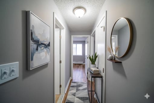 A hallway with a round mirror on the wall.