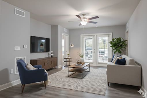 A living room with a blue chair and a grey couch.