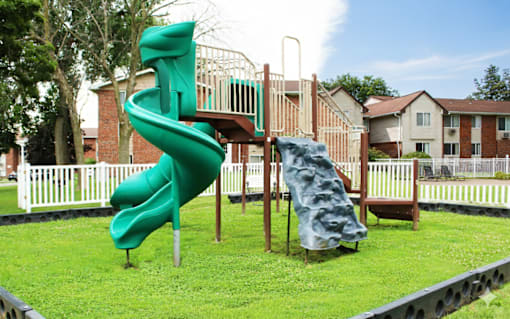 A green and blue slide in a playground.