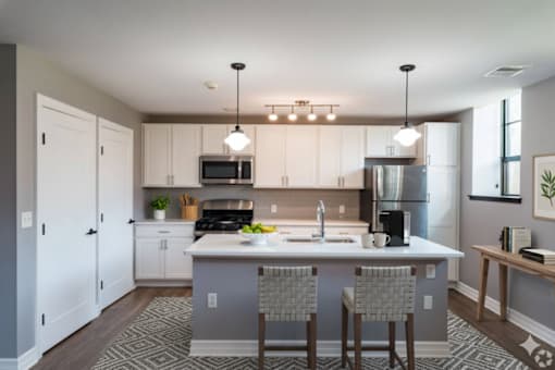 A kitchen with a large island and a refrigerator.