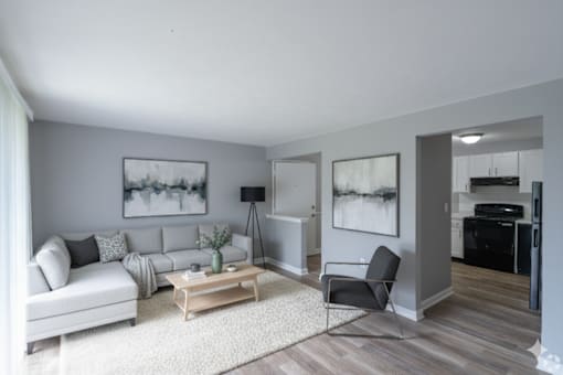 A living room with a white couch, a coffee table, and a chair.