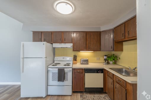 A kitchen with a white refrigerator, white stove, and white oven.