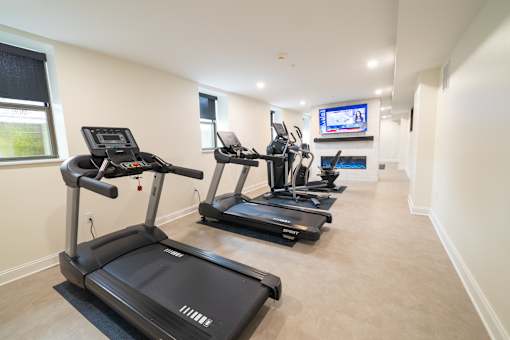 A spacious room with treadmills and a television.