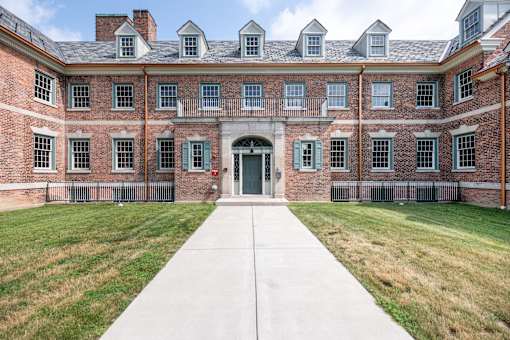 A large brick building with a long walkway in front.