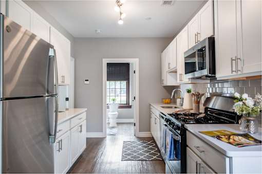 A kitchen with a stainless steel refrigerator and a stainless steel stove.