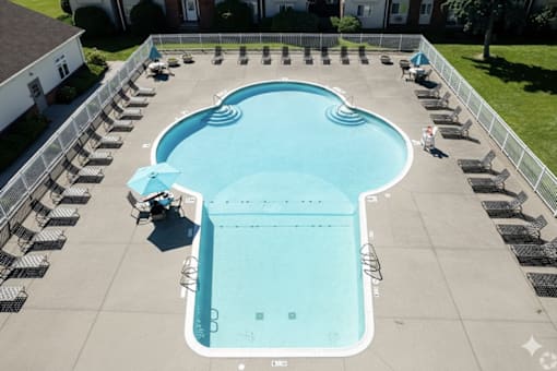 A large outdoor swimming pool surrounded by lounge chairs.