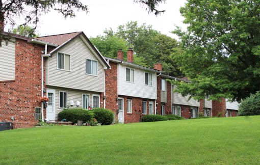a row of houses on a green lawn