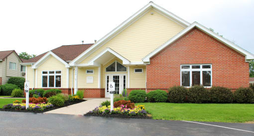 the front of a house with a lawn and flower beds