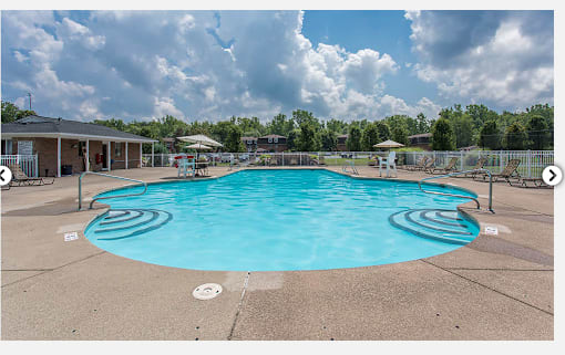 A large swimming pool with a sunny sky above.