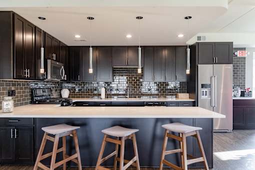 A kitchen with black cabinets and a white island. at Woodland Ridge Apartments, Woodridge, 60517