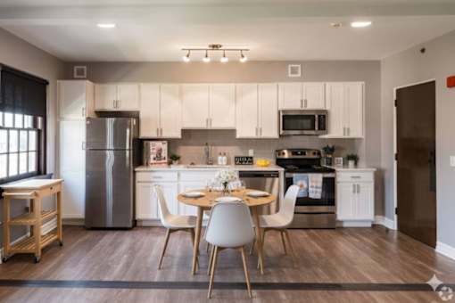 A modern kitchen with a dining table and chairs.