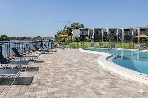 A pool area with a small pool and sun loungers.