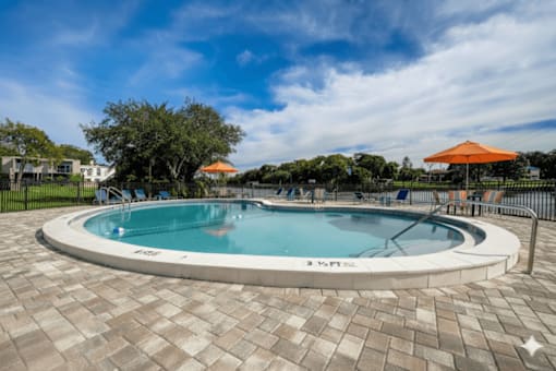 A round swimming pool surrounded by a brick patio.