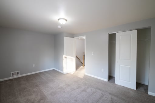 an empty living room with white doors and a carpet floor at Willowbrooke Apartments, Brockport, 14420