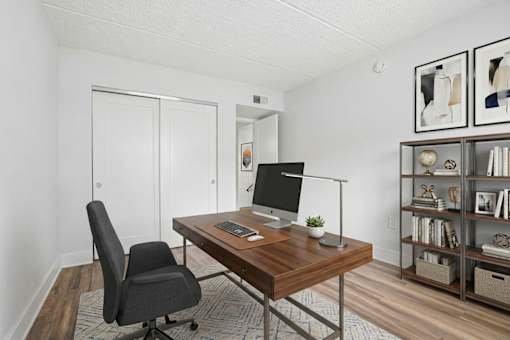 Home office with wooden desk and shelving at The Residences at Soho Apartments, Tampa, FL