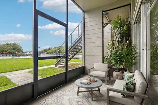 Screened patio with seating and waterfront view at The Residences at Soho Apartments, Tampa, 33607