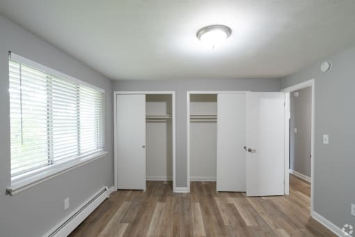 an empty room with a large window and a closet