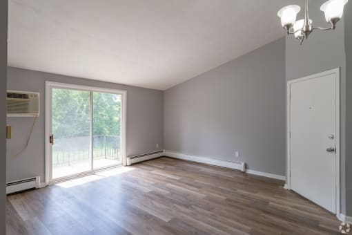 an empty living room with gray walls and a sliding glass door