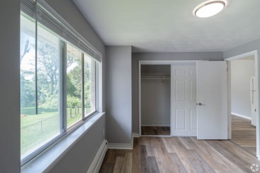 an empty room with a large window and a white door