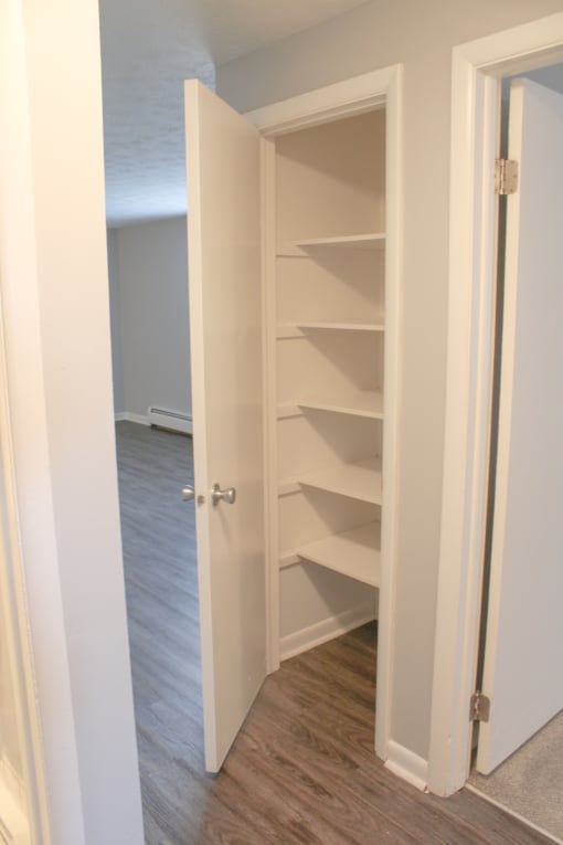 a closet with shelves and a door open at Willowbrooke Apartments, Brockport, New York
