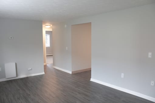an empty living room with wood floors and white walls at Willowbrooke Apartments, Brockport, 14420