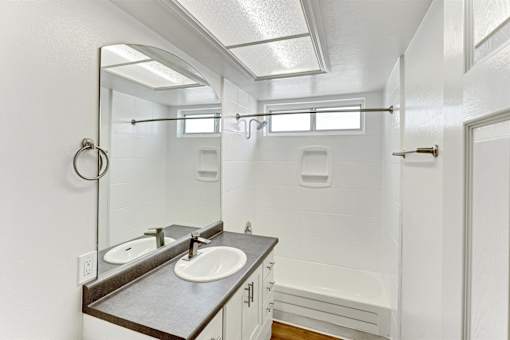 A bathroom with a sink vanity and a mirror above it.