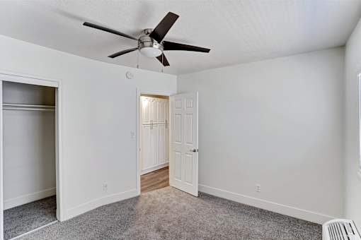 A room with a ceiling fan and a door.