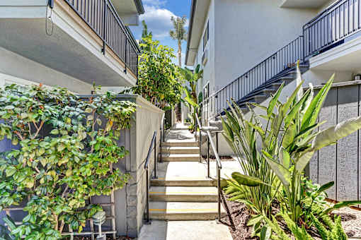 A staircase with a metal railing leads up to a balcony.