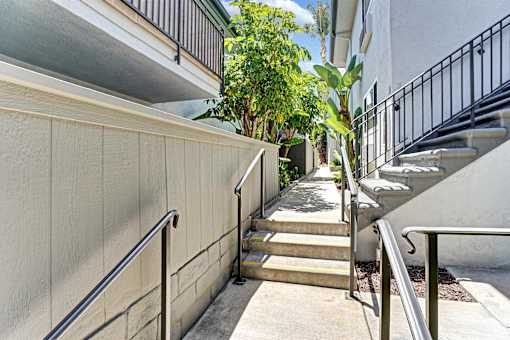 A staircase with a metal railing leads up to a building.