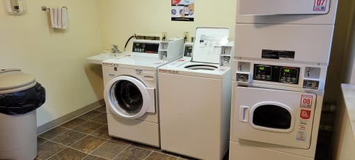 a laundry room with two washing machines and other appliances