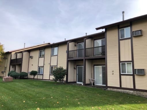 a row of apartment buildings with a grassy area in front of them