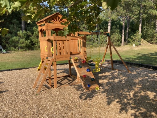 a swing set with a climbing frame and a slide in a backyard