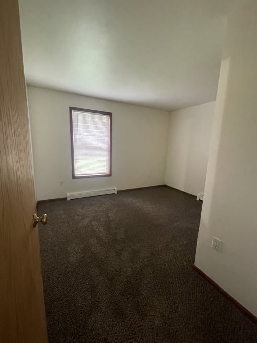 a small window in a room with a wooden floor