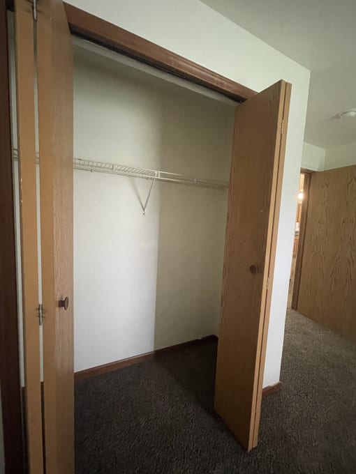 a wardrobe with an open door and a shelf above it