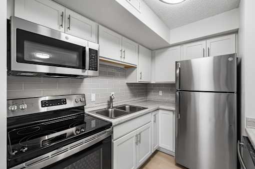 a kitchen with stainless steel appliances and white cabinets