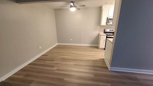 a living room with wood flooring and a ceiling fan