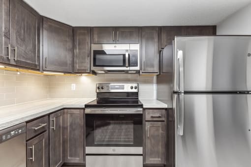 a kitchen with dark wood cabinets and stainless steel appliances